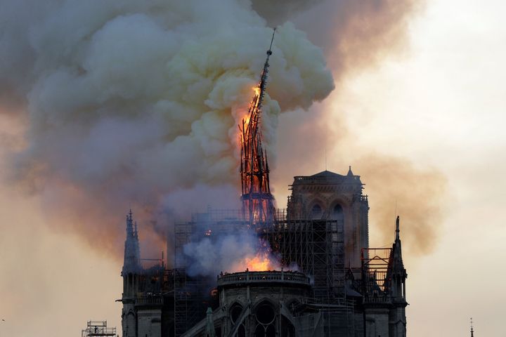 The steeple of the landmark Notre Dame Cathedral collapses as the cathedral is engulfed in flames in central Paris on April 15, 2019.