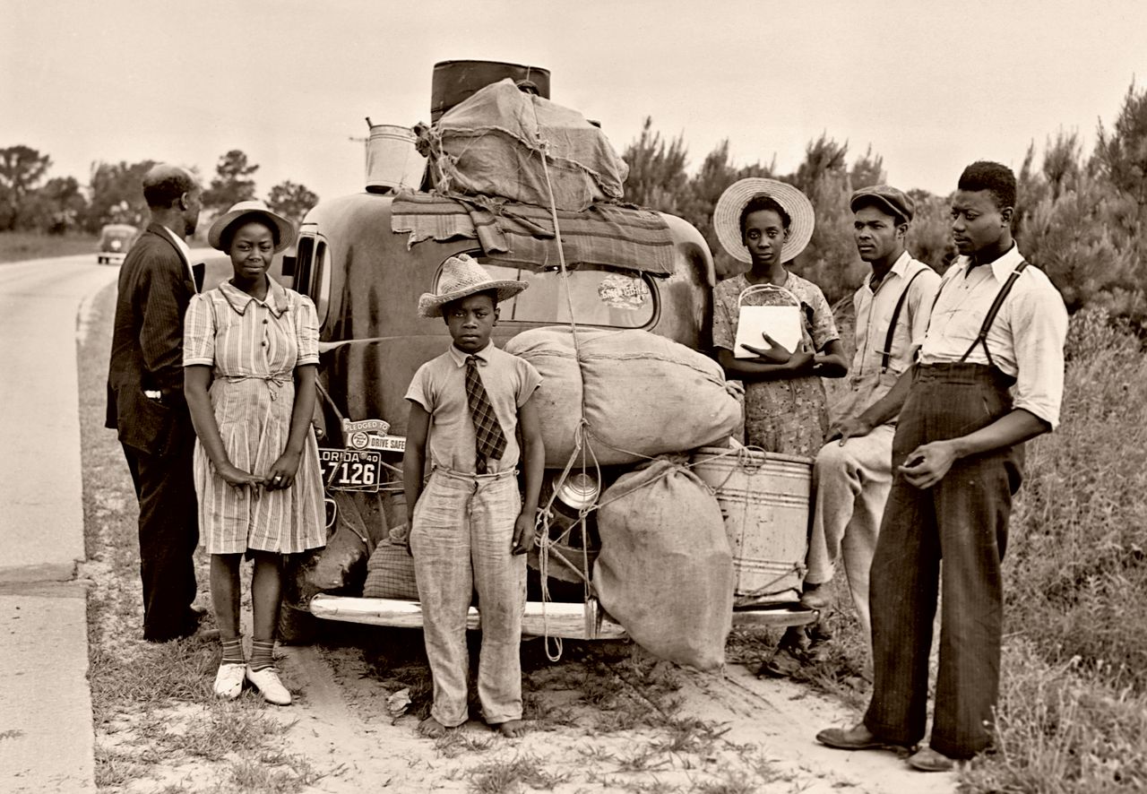 Migrant workers from Florida take a roadside break in Shawboro, North Carolina, on their way to pick potatoes in New Jersey, circa July 1940.