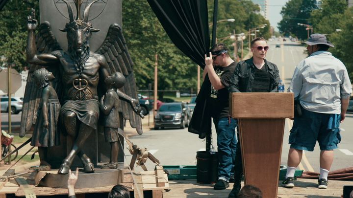 Satanic Temple co-founder Lucien Greaves delivers a speech in front of the Arkansas Capitol, with the group's Baphomet statue by his side.