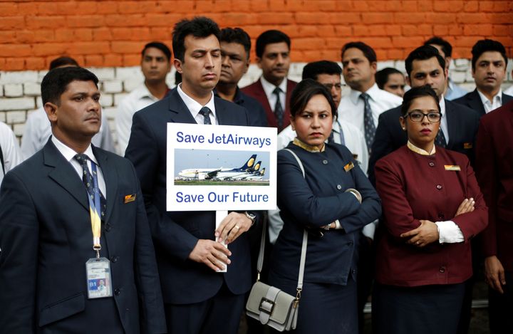 A Jet Airways employee holds a placard as he and others attend a protest demanding to "save Jet Airways".