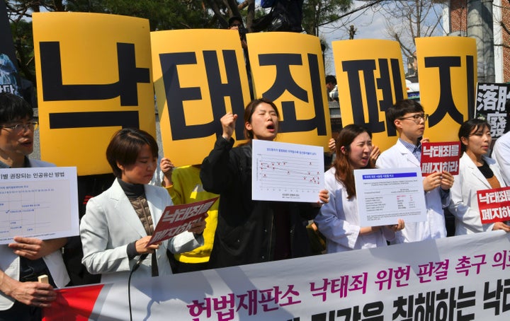 South Korean women's rights activists hold a rally against the abortion ban outside the Constitutional Court in Seoul on April 11. The yellow placards read "Abolish punishment for abortion."