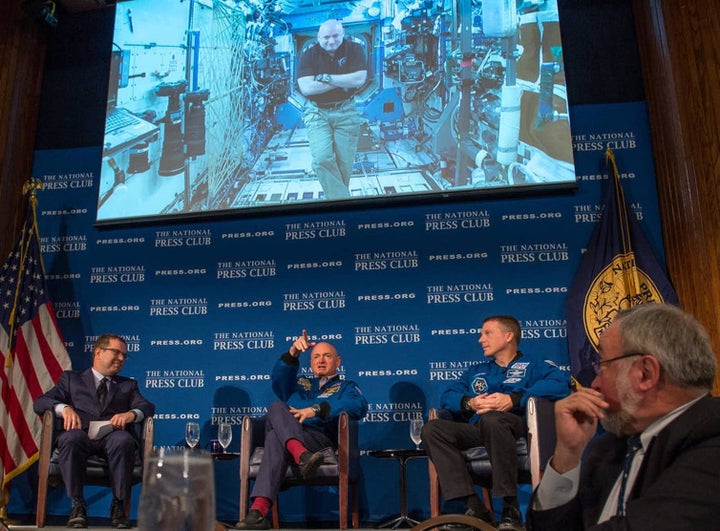 One day before astronaut Scott Kelly reaches the six-month mark in space, he talks live from onboard the ISS with John Hughs, left, his twin brother Mark Kelly and Astronaut Terry Virts, right.