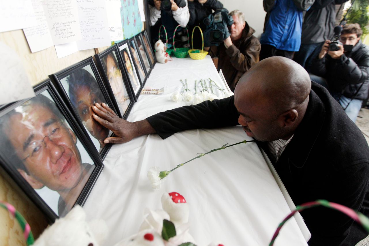 Efanye Chibuko touches a picture of his wife Doris during a memorial service at Oikos University the week after the attack.