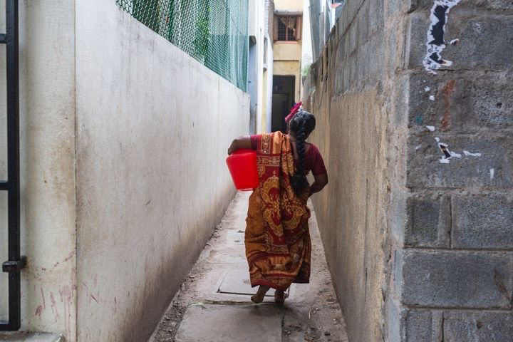 Kannika Arumugam returns home after collecting water from her local pump in Chennai, India.