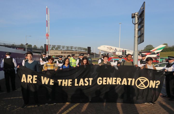 Young activists hold a banner at a protest near Heathrow Airport's main entrance on Friday.