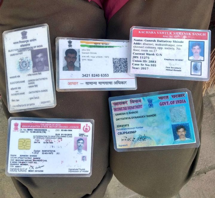Ganesh Shinde shows his ID cards.