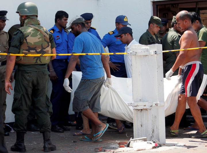 Men carry dead bodies towards ambulances near the St. Anthony's Shrine, Kochchikade church after an explosion in Colombo, Sri