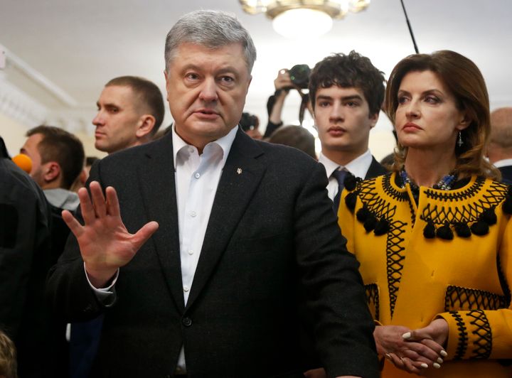 Ukrainian President Petro Poroshenko gestures while speaking to the media as her wife Maryna stands next to him, at a polling station, during the second round of presidential elections in Kiev, Ukraine, Sunday, April 21, 2019. (AP Photo/Efrem Lukatsky)