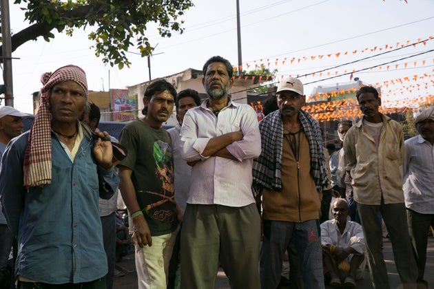 Laborers stand on the side of the road hoping to pick up