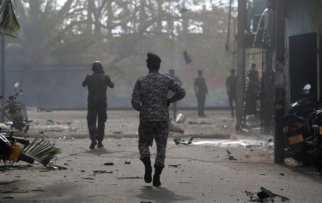 Sri Lankan security forces approach the site after a vehicle parked near St. Anthony's shrine exploded...