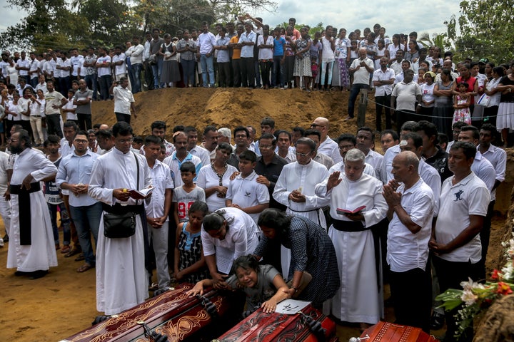 A woman weeps next to coffins during a funeral near St. Sebastian's Church in Negombo, Sri Lanka, April 23, 2019.