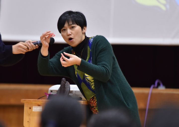 大津商業高校の1年生らにコンドームの付け方を教える清水美春さん＝大津市
