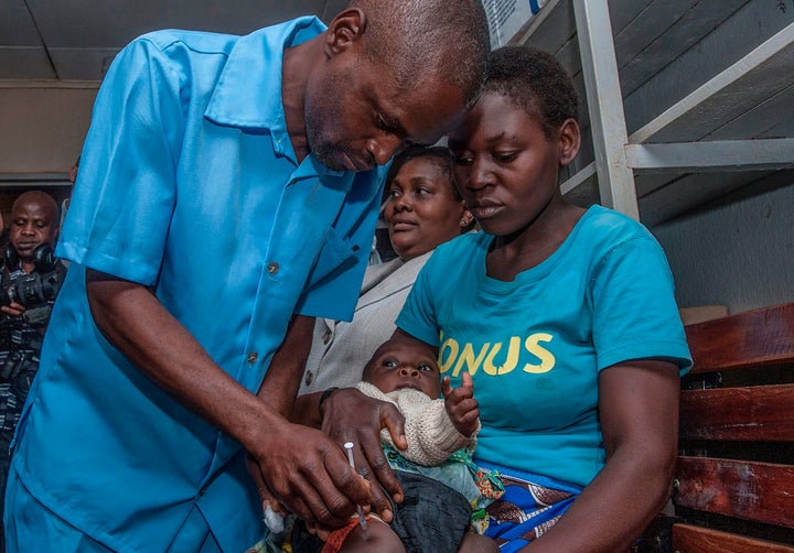 A health worker gives a dose of a malaria vaccine to a young child in Malawi. 