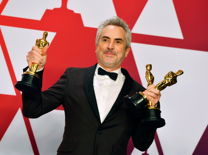 "Roma" director Alfonso Cuarón holding the film's three Oscars.