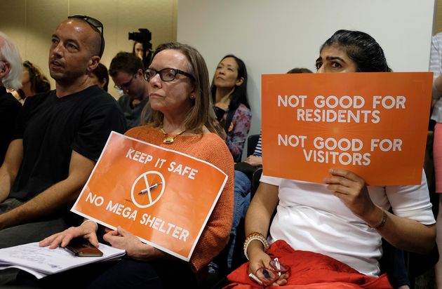Opponents of the shelter held signs at the meeting with pictures of
