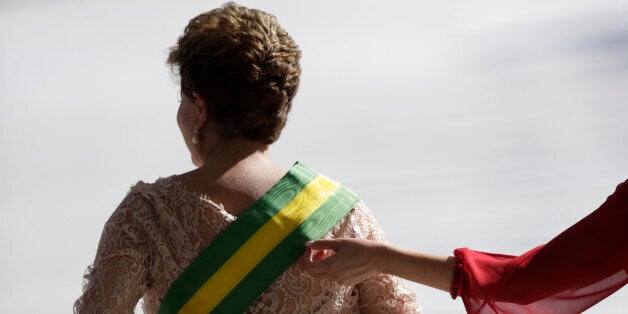 Brazil's President Dilma Rousseff gets the presidential sash adjusted by her daughter Paula after being sworn in for a second four-year term in Brasilia January 1, 2015. Brazil's President Dilma Rousseff began her second term Thursday vowing to rein in government spending to curb inflation and pull Latin America's largest economy out of a four-year slump. REUTERS/Ueslei Marcelino (BRAZIL - Tags: POLITICS)