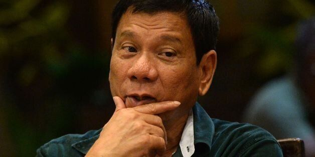 This photo taken on May 15, 2016 shows Philippines' president-elect Rodrigo Duterte gesturing as he talks with military and police officials during an informal meeting at a hotel in Davao City, in the southern island of Mindanao. Business titans, turncoat politicians, celebrities and rebel leaders are descending on the long-neglected far southern Philippines, hoping to gain favour with the nation's shock new powerbroker. The remote and dusty city of Davao has suddenly become the country's new seat of power after hometown hero Rodrigo Duterte won last week's presidential election in a landslide. / AFP / TED ALJIBE (Photo credit should read TED ALJIBE/AFP/Getty Images)