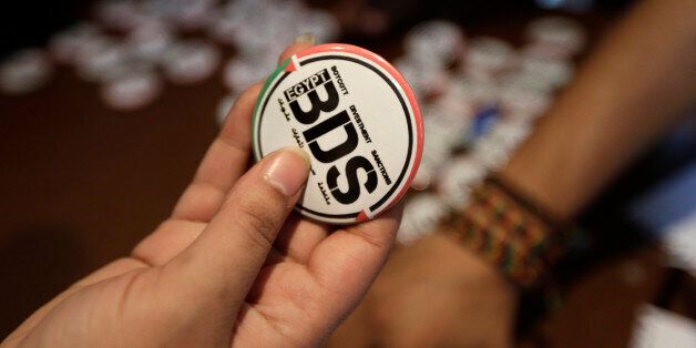 An Egyptian buys a pin with the Boycott, Divestment and Sanctions (BDS) logo during the launch of the Egyptian campaign that urges boycott, divestment and sanctions against Israel and Israeli-made goods, at the Egyptian Journalistsâ Syndicate in Cairo, Egypt, Monday, April 20, 2015. BDS is a global movement initiated by Palestinian civil society activists in 2005 that organizers say will continue until Israel complies with international law and respects Palestinian rights. (AP Photo/Amr Nabil)