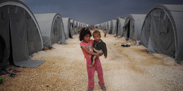 SANLIURFA, TURKEY - OCTOBER 28: (TURKEY OUT) Kurdish refugee children from the Syrian town of Kobani look on near makeshift tents in a camp in the southeastern town of Suruc, Sanliurfa province October 28, 2014. Kurdish fighters, supported by US-led air strikes, have fended off the Islamic State militants offensive into the besieged Syrian border town of Kobani for the last 44 days but remain ill equipped and short on ammunition. (Photo by Kutluhan Cucel/Getty Images)