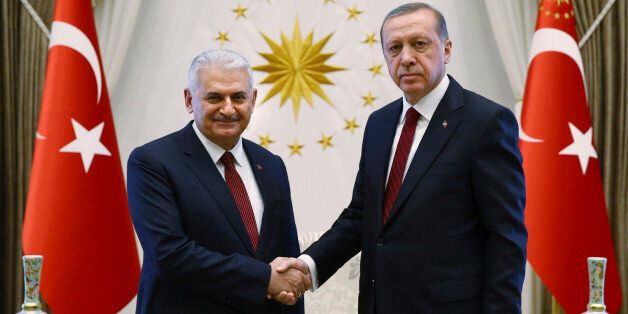 Turkey's President Recep Tayyip Erdogan, right and Turkey's incoming prime minister Binali Yildirim shake hands prior to the government's first cabinet meeting at the Presidential Palace in Ankara, Turkey, Wednesday, May 25, 2016. Erdogan had approved the new government formed by Yildirim, one of his most trusted allies, who immediately asserted the intention to institute constitutional reforms that would expand the powers of the presidency. (Presidential Press Service/Pool Photo via AP)