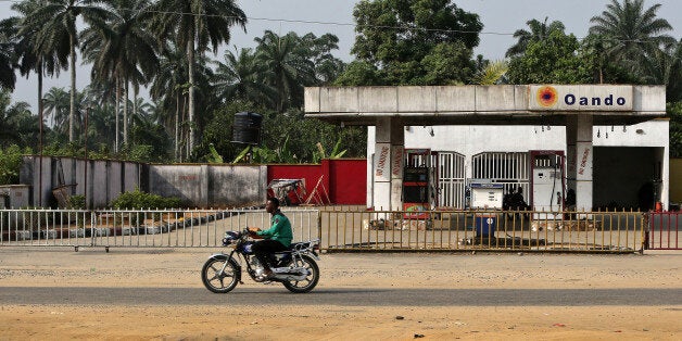 A man rides a motorcycle past a closed Oando Plc gas station in Port Harcourt, Nigeria, on Thursday, Jan. 14, 2016. With his security forces engaged in fighting Boko Haram's Islamist insurgency in the north, President Muhammadu Buhari can't afford renewed rebellion in the delta. Photographer: George Osodi/Bloomberg via Getty Images