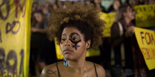 A woman wearing a female gender symbol attends a protest against the gang rape of a 16-year-old girl in Rio de Janeiro, Brazil, Friday, May 27, 2016. The assault last Saturday came to light after several men joked about the attack online, posting graphic photos and videos of the unconscious, naked teen on Twitter. (AP Photo/Leo Correa)