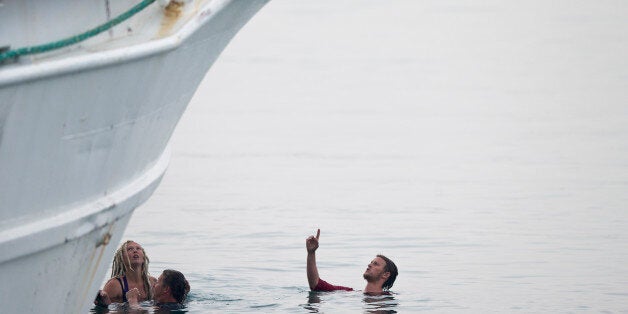 Activists in the sea try to interfere the deportation of Pakistani migrants on board a ferry set to sail for Turkey in the po
