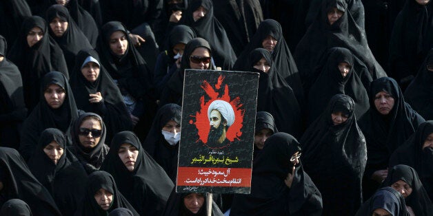 FILE -- In this Monday, Jan. 4, 2016 file photo, an Iranian woman holds up a poster showing Sheikh Nimr al-Nimr, a prominent opposition Saudi Shiite cleric who was executed by Saudi Arabia, in Tehran, Iran. Diplomatic tensions between Saudi Arabia and Iran, which began with the kingdomâs execution of al-Nimr and later saw attacks on Saudi diplomatic posts in the Islamic Republic, have seen countries around the world respond. On Tuesday, Jan. 5, 2016, President Hassan Rouhani said that Saudi Arabiaâs move to sever ties with his country couldnât âcover its crimeâ of executing al-Nimr. (AP Photo/Vahid Salemi, File)