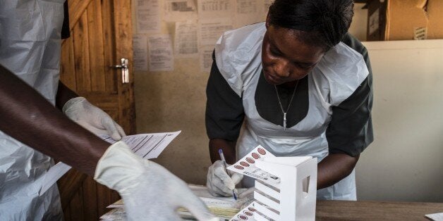 Lab technician Mathias Semba (L), 27, organizes blood samples at the Tengani health center in the Nsanje district of southern Malawi on November 25, 2014 before sending them to Thyolo where they will be tested a a viral load lab. The World Health Organization (WHO) says there were some 35 million people around the world living with HIV by the end of 2013, with some 2.1 million new infections during the course of that year. Sub-Saharan Africa is the most affected region, with almost 70 percent of new infections. AFP PHOTO/MARCO LONGARI / AFP / MARCO LONGARI (Photo credit should read MARCO LONGARI/AFP/Getty Images)