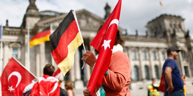 Demonstrators hold Turkish and German flags in front of the Reichstag, the seat of the lower house of parliament Bundestag in