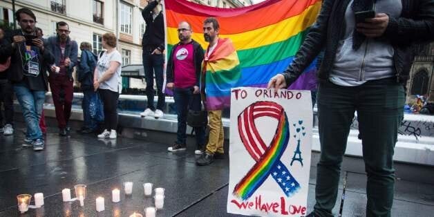 People and members of the gay community gather for a vigil near the Beaubourg art center in downtown Paris on June 12, 2016,
