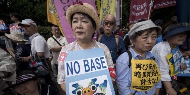 TOKYO, JAPAN - JUNE 19: Anti-U.S. airbase demonstrators protest the U.S. Airbase relocation to Henoko in front of the Japanese Parliament in Tokyo, Japan on June 19, 2016. Protests over the US military presence in Japan have grown more intense over past days due to previous incidents including the alleged rape of a Japanese woman and drunk driving in Okinawa by American military personnel. (Photo by Nicolas Datiche/Anadolu Agency/Getty Images)