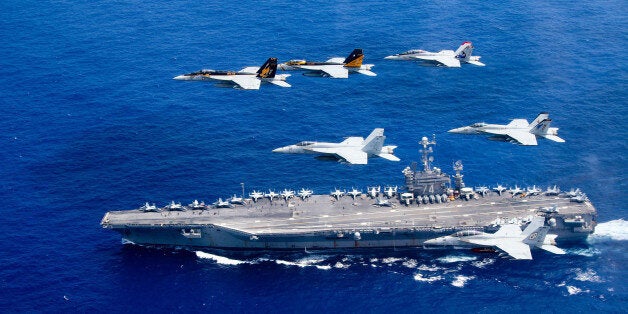 PHILIPPINE SEA - JUNE 18: In this handout provided by the U.S. Navy, a combined formation of aircraft from Carrier Air Wing (CVW) 5 and Carrier Air Wing (CVW) 9 pass in formation above the Nimitz-class aircraft carrier USS John C. Stennis (CVN 74). The formation included F/A-18 Hornets from the Black Aces of Strike Fighter Squadron (VFA) 41, the Diamondbacks of Strike Fighter Squadron (VFA) 102, the Eagles of Strike Fighter Squadron (VFA) 115, the Royal Maces of Strike Fighter Squadron (VFA) 27, the Vigilantes of Strike Fighter Squadron (VFA) 151, and the Warhawks of Strike Fighter Squadron (VFA) 97. The Nimitz-class aircraft carriers USS John C. Stennis and USS Ronald Reagan (CVN 76) are conducting dual aircraft carrier strike group operations in the U.S. 7th Fleet area of operations in support of security and stability in the Indo-Asia-Pacific. (Photo by Lt. Steve Smith/U.S. Navy via Getty Images)