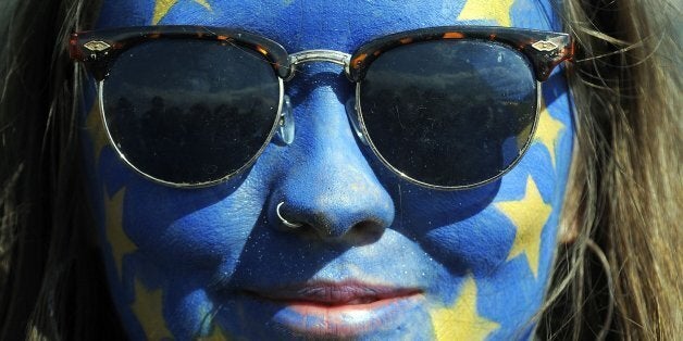 A festival-goer with a European flag painted on her face poses for a photograph on day three of the Glastonbury Festival of M