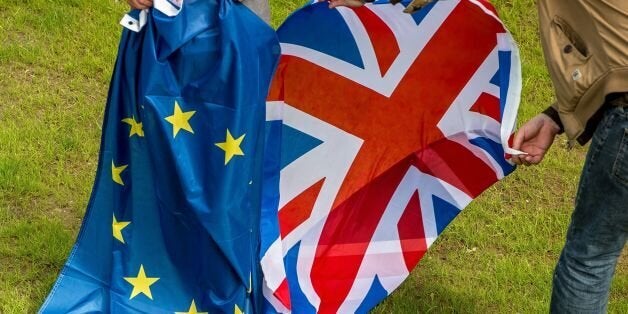 Two people hold an European Union and United Kingdom at the castle of Hardelot, the cultural center of the Entente Cordiale (the colonial-era promise of cross-channel friendship between Britain and France) in Neufchatel-Hardelot, northern France. Britain has voted to break out of the European Union, striking a thunderous blow against the bloc and spreading panic through world markets on June 24, 2016 as sterling collapsed to a 31-year low. / AFP / PHILIPPE HUGUEN (Photo credit should read PHILIPPE HUGUEN/AFP/Getty Images)