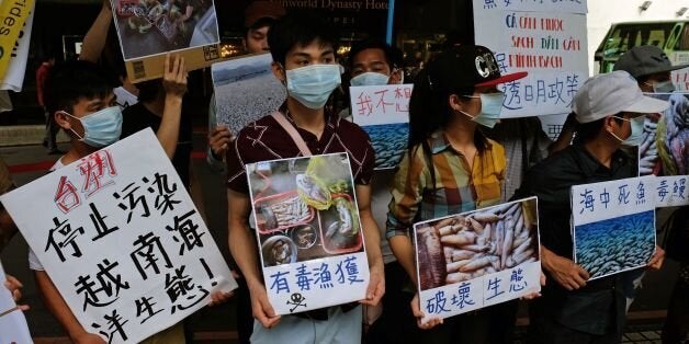 Vietnamese living in Taiwan display placards and images of dead fish, claimed by protesters to be caused by Taiwan's Formosa group industry waste water, during a demonstration in Taipei on June 18, 2017.Taiwanese lawmakers urged the government on June 16 to investigate local conglomerate Formosa's possible role in mass fish deaths in Vietnam, as activists said industrial pollution from its multi-billion dollar steel plant could have caused the environmental disaster. / AFP / SAM YEH (Photo credit should read SAM YEH/AFP/Getty Images)