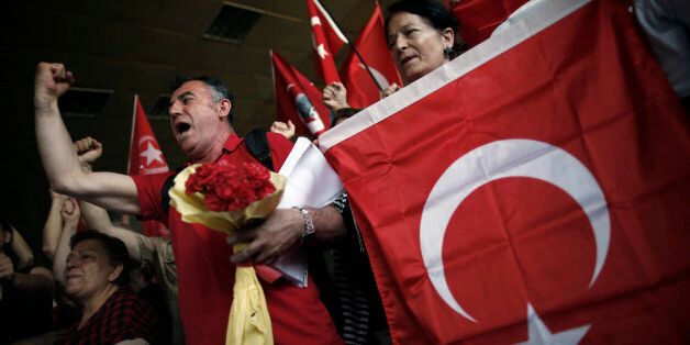 Colleagues shout slogans to condemn terrorism as they stage a memorial ceremony for Erol Eskisoy and Ali Zulfukar Yorulmaz, two taxi drivers killed in Tuesday blasts at the entrance of Ataturk Airport in Istanbul, Thursday, June 30, 2016. A senior Turkish official on Thursday identified the Istanbul airport attackers as a Russian, Uzbek and Kyrgyz national hours after police carried out sweeping raids across the city looking for Islamic State suspects. Turkish authorities have banned distribution of images relating to the Ataturk airport attack within Turkey.(AP Photo/Emrah Gurel)