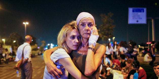 Passengers embrace each other as they wait outside Istanbul's Ataturk airport, early Wednesday, June 29, 2016 following their evacuation after a blast. Suspected Islamic State group extremists have hit the international terminal of Istanbul's Ataturk airport, killing dozens of people and wounding many others, Turkish officials said Tuesday. Turkish authorities have banned distribution of images relating to the Ataturk airport attack within Turkey. (AP Photo/Emrah Gurel) TURKEY OUT