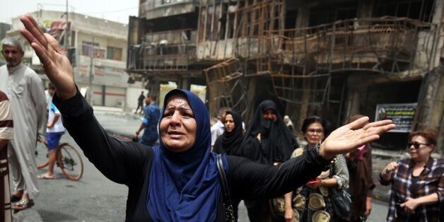 An Iraqi woman reacts on July 4, 2016 at the site of a suicide-bombing attack which took place a day earlier in Baghdad's Karrada neighbourhood .Iraqis mourned the more than 200 people killed by a jihadist-claimed suicide car bombing that was among the deadliest ever attacks in the country. The blast, which the Islamic State group said it carried out, hit the Karrada district early on July 3 as the area was packed with shoppers ahead of this week's holiday marking the end of the Muslim fasting month of Ramadan. / AFP / AHMAD AL-RUBAYE (Photo credit should read AHMAD AL-RUBAYE/AFP/Getty Images)