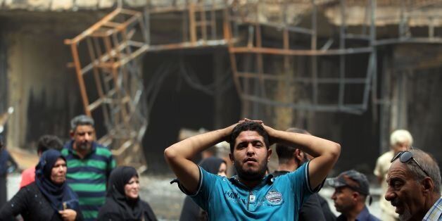 Iraqis react on July 4, 2016 at the site of a massive bombing attack which took place a day earlier in Baghdad's Karrada neighbourhood.Iraqis mourned the more than 200 people killed by a jihadist-claimed suicide car bombing that was among the deadliest ever attacks in the country. The blast, which the Islamic State group said it carried out, hit the Karrada district early on July 3 as the area was packed with shoppers ahead of this week's holiday marking the end of the Muslim fasting month of Ramadan. / AFP / AHMAD AL-RUBAYE (Photo credit should read AHMAD AL-RUBAYE/AFP/Getty Images)