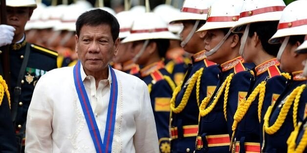 Philippine President Rodrigo Duterte walks past honour guards before Philippine National Police (PNP) chief Ronald Bato Dela