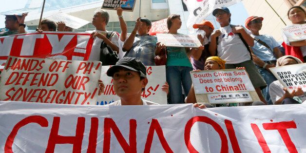 Protesters display their message during a rally outside of the Chinese Consulate hours before the Hague-based UN international arbitration tribunal is to announce its ruling on South China Sea Tuesday, July 12, 2016, in Makati city east of Manila, Philippines. The protesters are urging China to respect the Philippines' rights over its exclusive economic zone and extended continental shelf as mandated by the UN Convention of the Law of the Sea or UNCLOS. (AP Photo/Bullit Marquez)