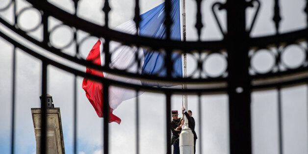 A Republican Guard lowers the French national flag at half-mast at the Elysee Palace in Paris, France, July 15, 2016, the day after the Bastille Day truck attack in Nice. REUTERS/Christophe Petit Tesson/Pool 