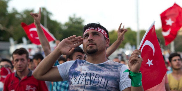 A protester salutes as he takes part in a rally in Taksim Square, Istanbul, Sunday, July 17, 2016. The Turkish government accelerated its crackdown on alleged plotters of the failed coup against President Recep Tayyip Erdogan, with the justice minister saying Sunday that 6,000 people had been detained in the investigation, including three of the country's top generals and hundreds of soldiers. (AP Photo/Petros Giannakouris)