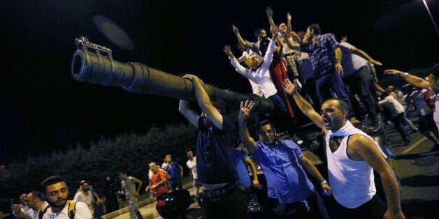 People stand on a Turkish army tank at Ataturk airport in Istanbul, Turkey July 16, 2016. REUTERS/Huseyin Aldemir