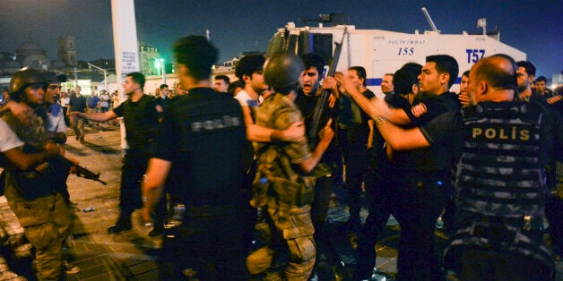 Turkish soldiers, arrested by civilians, are handed to police officers in Taksim Square in Istanbul, Turkey, early Saturday,