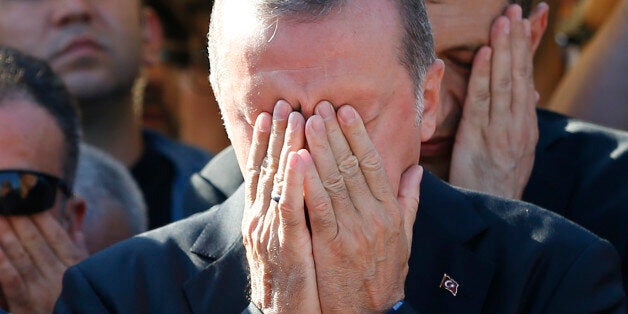 Turkish President Recep Tayyip Erdogan prays during a funeral service for a victim of the thwarted coup in Istanbul, Turkey,