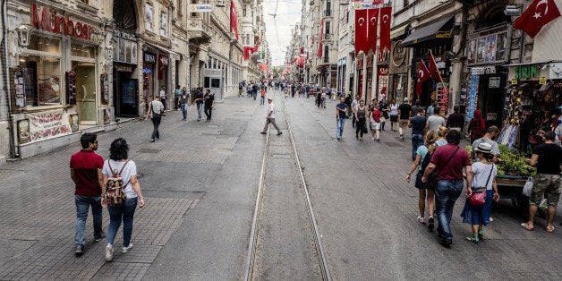 Visitors walk past retail stores along a half empty Taksim street in Istanbul, Turkey, on Monday, July 18, 2016. Tourism is an essential source of foreign currency to finance Turkey's current-account deficit and employs 8 percent of the nation's workforce. Photographer: Ismail Ferdous/Bloomberg via Getty Images