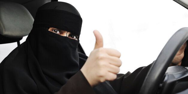 Arabic Muslim woman with veil and scarf (hijab and niqab) driving car. Note: In some arabic countries like Saudi Arabia driving a car by woman is forbiden.