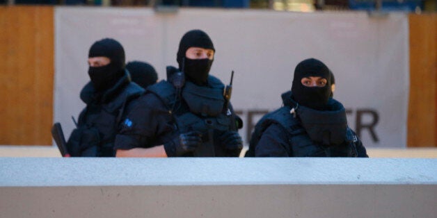 Special force police officers stand guard at an entrance of the main train station, following a shooting rampage at the Olymp